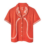 Short-sleeve terry cloth shirt in bright orange with white embroidered lobsters on the collar and coiled telephone cord detailing along the front and sleeves.