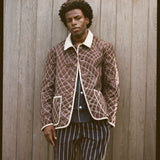 Man wears brown jacket and striped pants