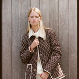 Woman looks at camera in quilted jacket