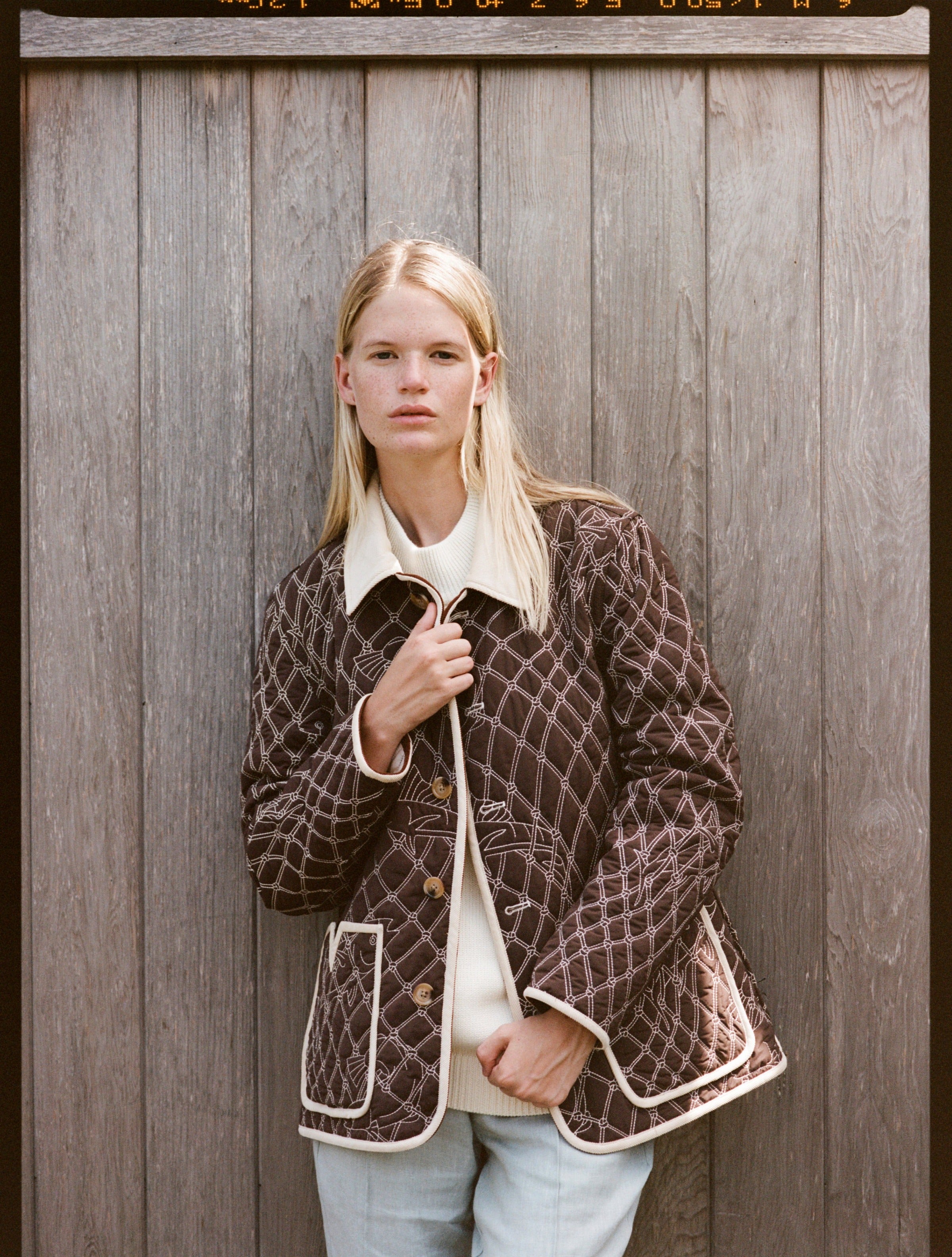Woman looks at camera in quilted jacket
