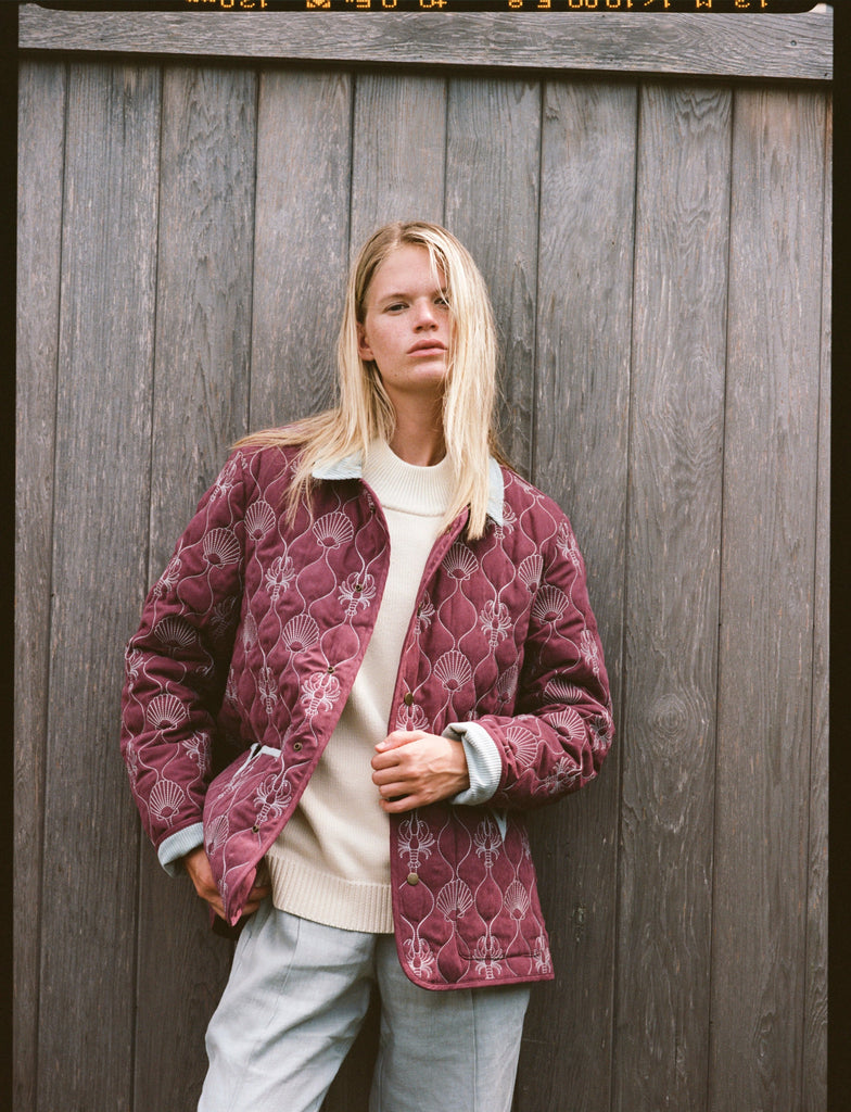 Woman holds jacket with her left hand 