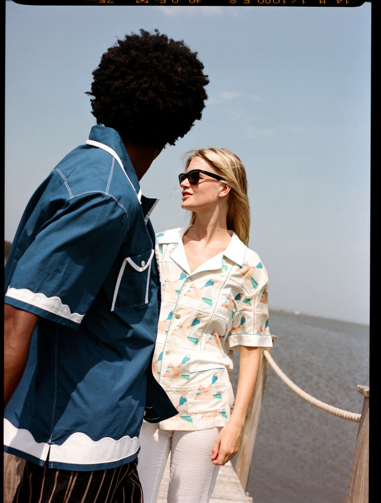 Man looks away from camera at woman on dock
