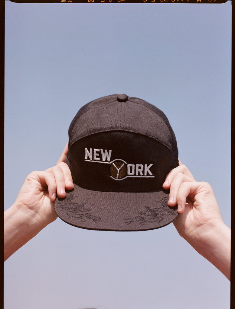 two hands hold the souvenir cap to the sky 