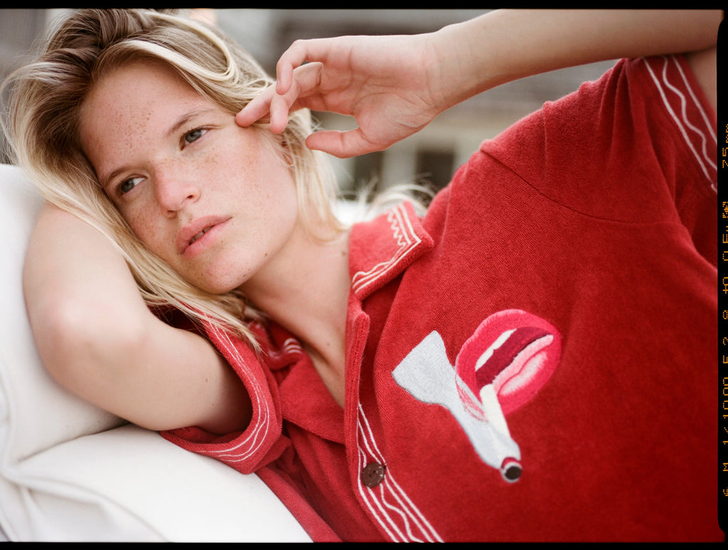Woman lies on beach chair with smoking lips motif on shirt