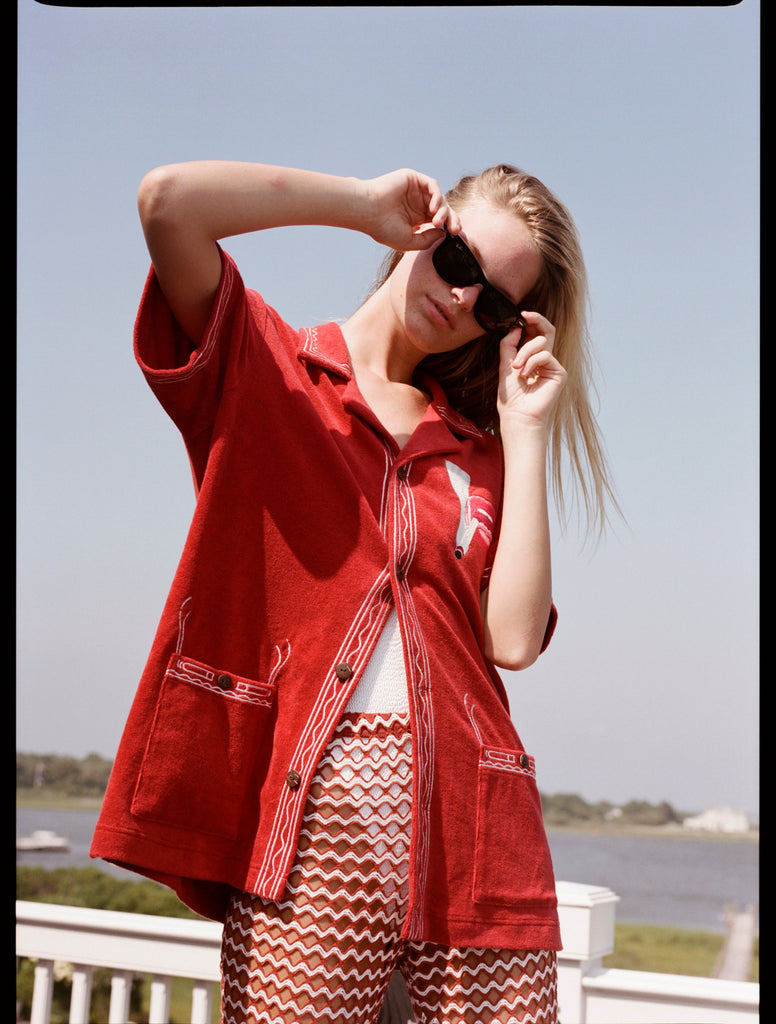 Woman stares at camera holding sunglasses