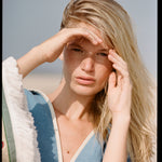 woman holds hand over eyes to cover the sun 