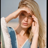 woman holds hand over eyes to cover the sun 