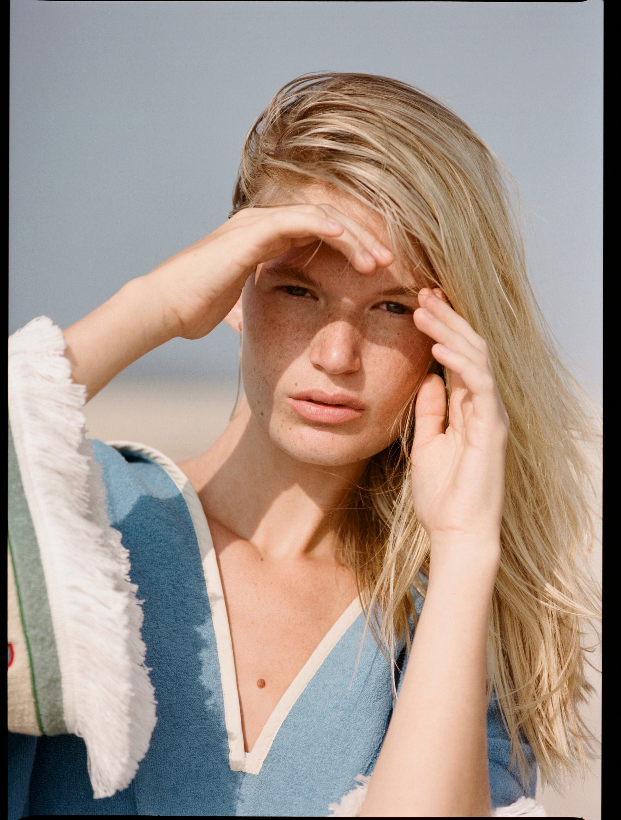 woman holds hand over eyes to cover the sun 