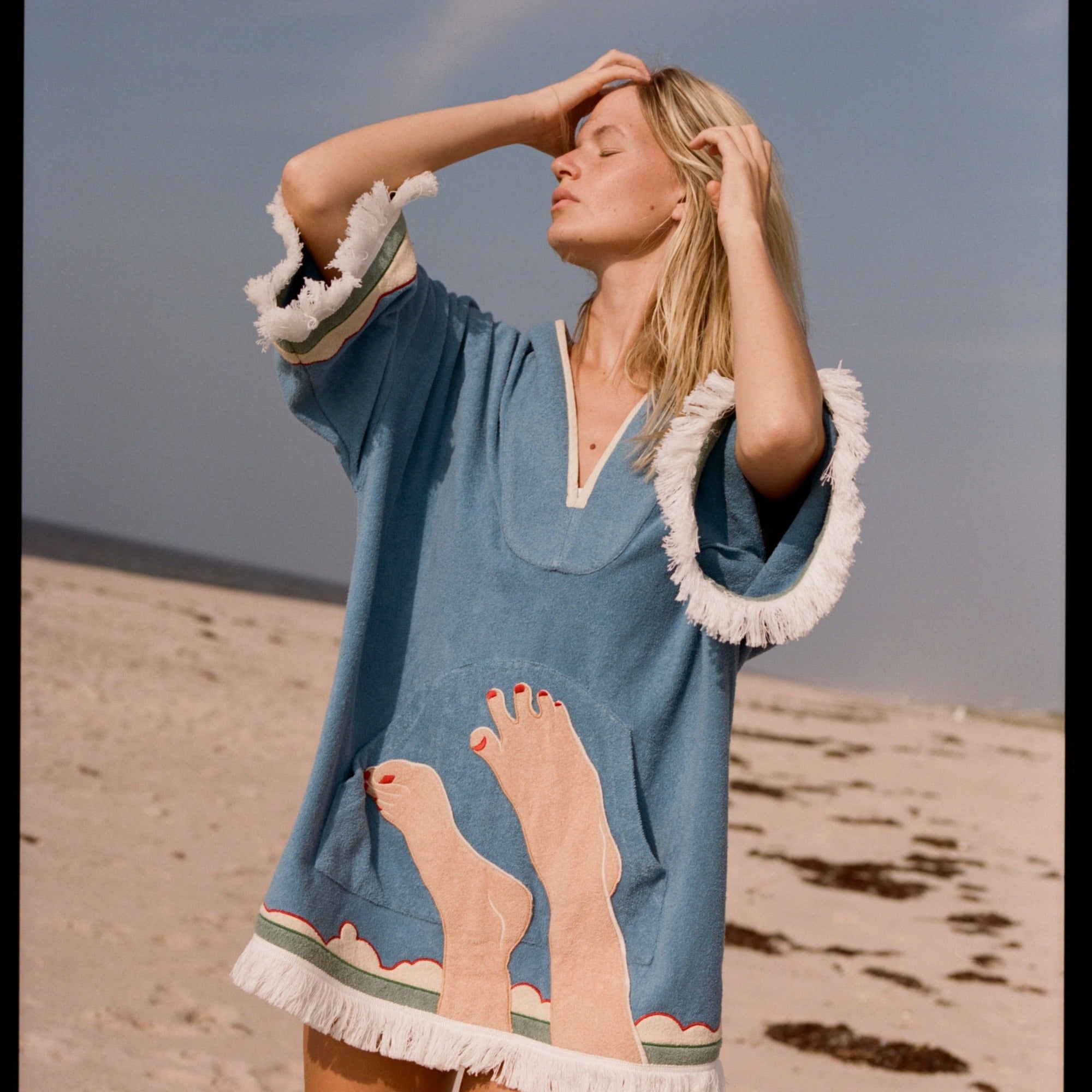 woman closes eyes with hands in her hair