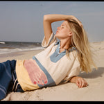 Woman lies sideways on the back with one hand over her face