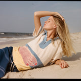 Woman lies sideways on the back with one hand over her face
