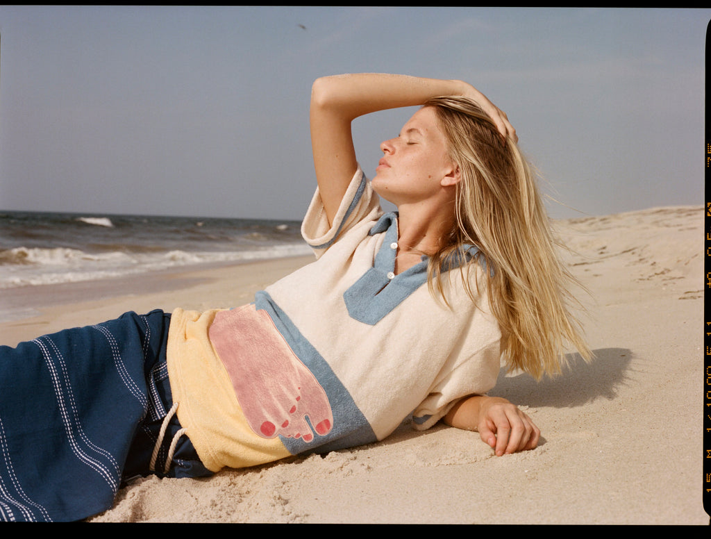 Woman lies sideways on the back with one hand over her face