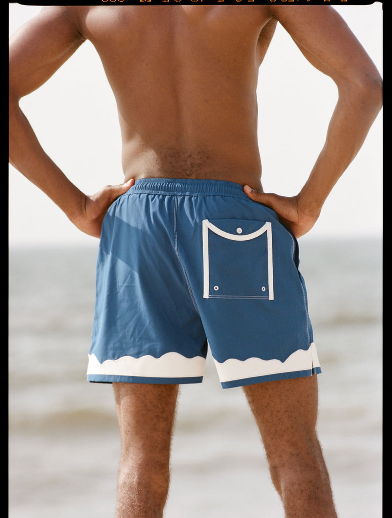 Shot of the backside of a model at the beach wearing the swim trunks