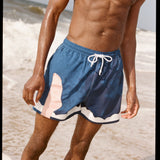 Photo of model wearing swim trunks after a dip in the ocean