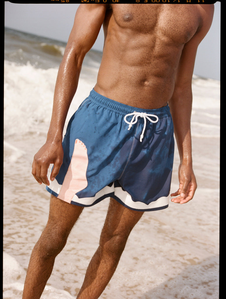 Photo of model wearing swim trunks after a dip in the ocean
