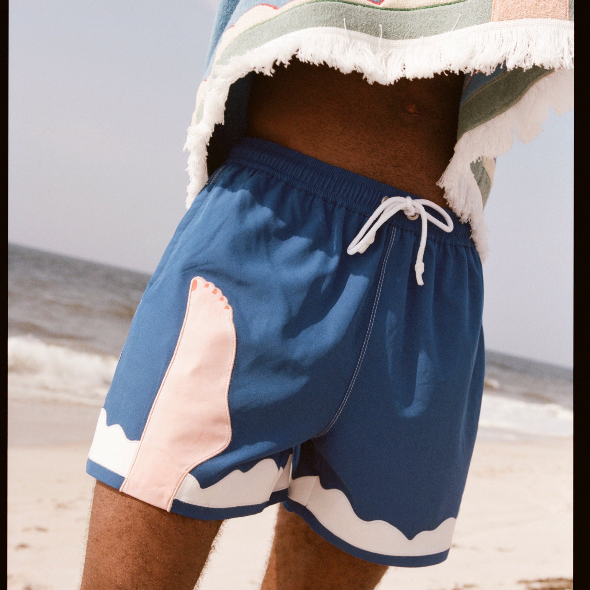 Seascape #2 swim trunks being worn by a model on the beach