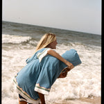 woman puts arm around man as they run along the beach