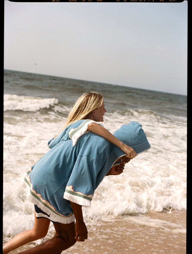 woman puts arm around man as they run along the beach