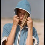 woman stares at camera with hair falling out of hood