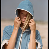 woman stares at camera with hair falling out of hood