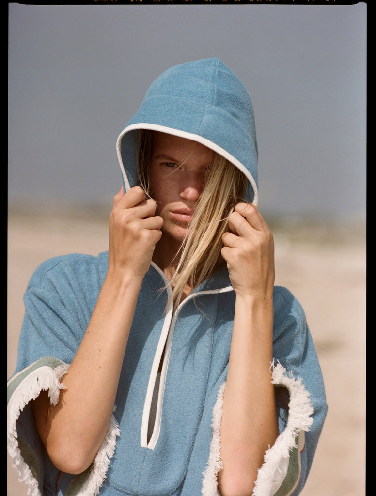 woman stares at camera with hair falling out of hood