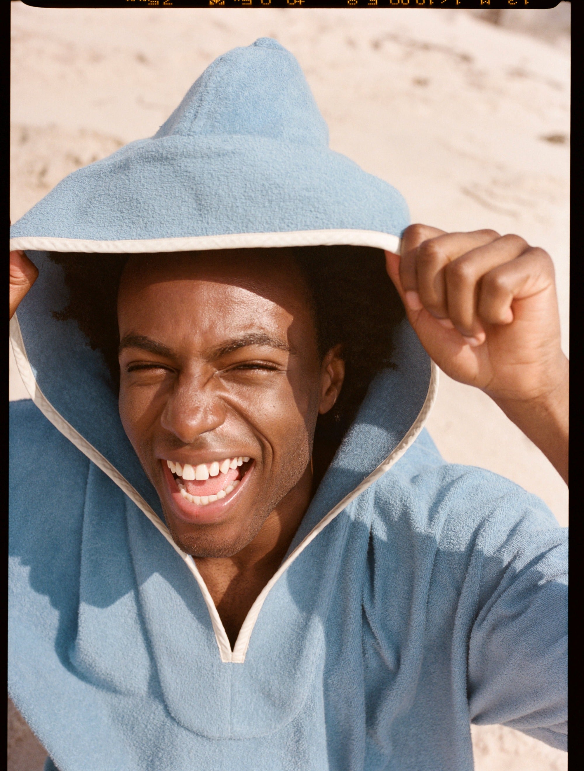 man smiles and looks up at camera
