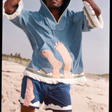 man looks above camera holding hood over head