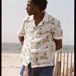 Man places hands behind back and looks off into the distance