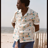 Man places hands behind back and looks off into the distance