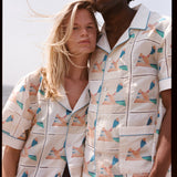 Man and woman lean together in matching shirts