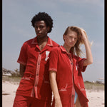 Man in woman pose on the beach wearing matching sets