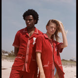 Man in woman pose on the beach wearing matching sets