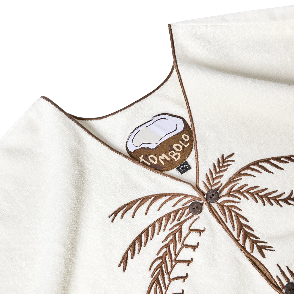 A detailed shot of the shirt's interior label, which features a half coconut with "Tombolo" written across. 