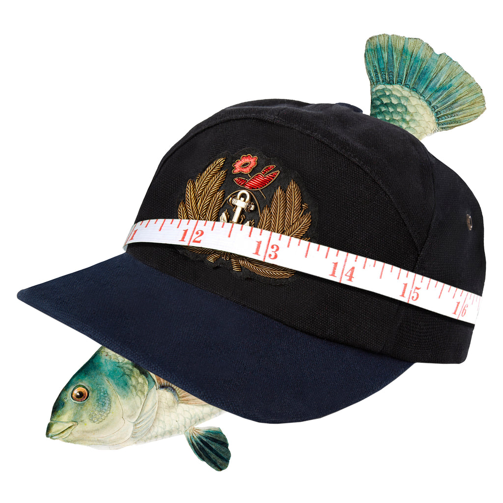 Tombolo cap with tape measure across front and fish in background