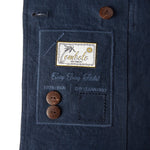 Close up image of the Tombolo tag on the inside of the jacket that features two spare buttons.
