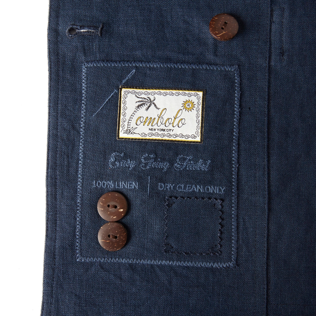 Close up image of the Tombolo tag on the inside of the jacket that features two spare buttons.