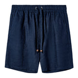 Front-facing image of a pair of navy linen shorts featuring an elastic waistband with a drawstring, side pockets, and wooden bead details on the drawstring ends.