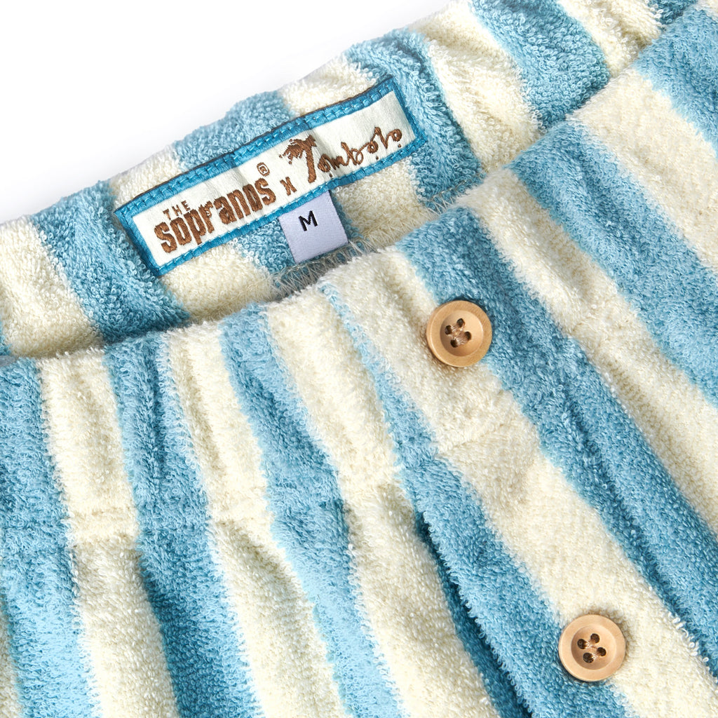 Close-up image of 'The Sopranos' Fowl Play Shorts that showcases its three wooden buttons and woven label on interior waistband that says "Sopranos x Tombolo."