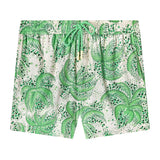 Front-facing product image of the 'Palm Fronds Swim Trunks (green)' that features a repeating vintage palm frond print throughout, zippered side pocket concealed on right side seam, and metal eyelet stoppers on green and white twist drawstrings.