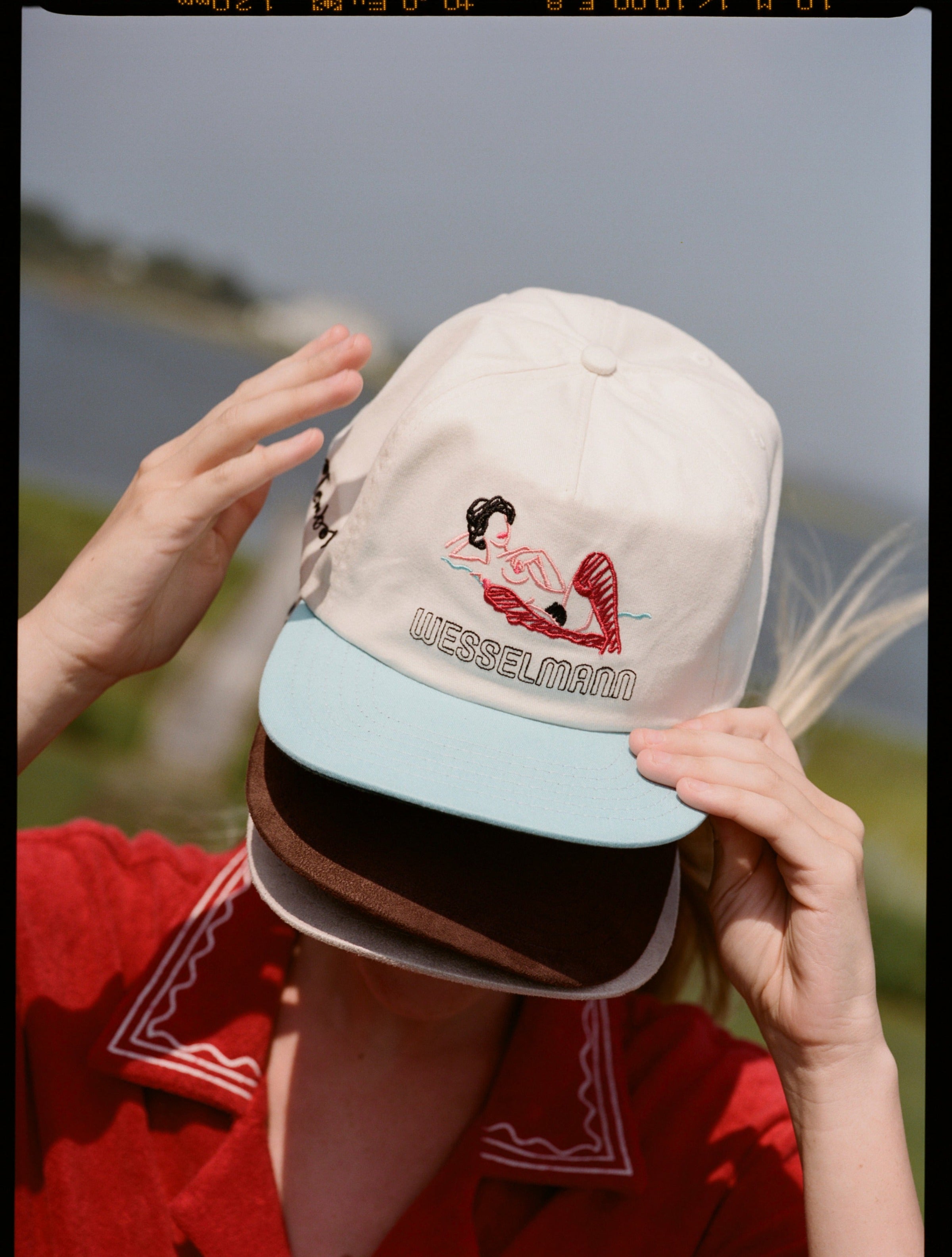 woman wears three caps covering her face