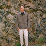 Man stares at camera wearing green quilted jacket