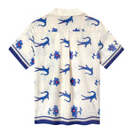 Back view of off-white shirt with digitally printed artwork of purple crocodiles and flowers in repeat. 