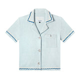 Front-facing product image for the 'Rick Rack' Cabana ~ Crop Cut (Sky Blue) made of Organic Cotton Terry Cloth and featuring oversized agoya shell buttons, signature Tombolo v-slit pocket on chest, overlapping rick rack embroidery on collar, cuffs, and bottom sweep, and a custom woven Tombolo label.