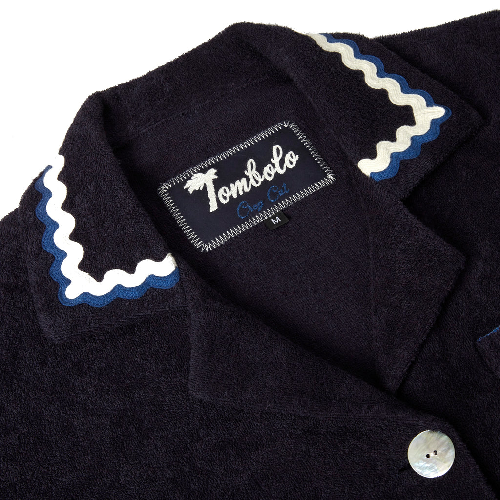 Close-up product image of the 'Rick Rack' Cabana ~ Crop Cut's (Midnight Blue) custom woven Tombolo label and oversized agoya shell buttons.
