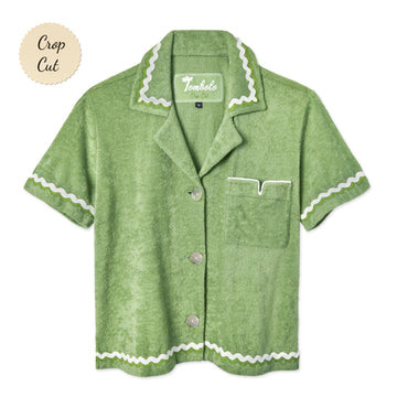 Front-facing product image of the 'Rick Rack' Cabana ~ Crop Cut (green) made of 100% Organic Cotton Terry Cloth that features oversized agoya shell buttons, signature Tombolo v-slit pocket on chest, overlapping rick rack embroidery on collar, cuffs, and bottom sweep, and a custom woven Tombolo label.