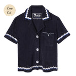 Front-facing product image of the 'Rick Rack' Cabana ~ Crop Cut (Midnight Blue) made of Organic Cotton Terry Cloth and featuring and featuring oversized agoya shell buttons, signature Tombolo v-slit pocket on chest, overlapping rick rack embroidery on collar, cuffs, and bottom sweep, and a custom woven Tombolo label.