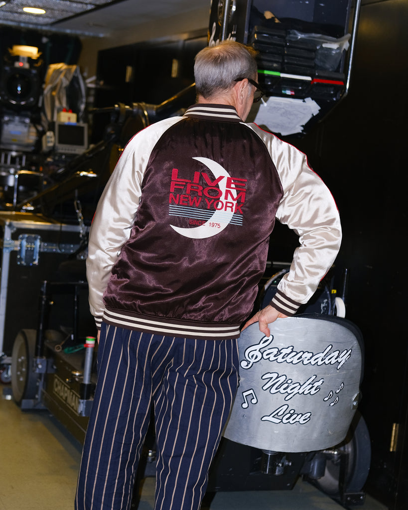 Tom Broecker standing with his back to the camera, showing off the back of the SNL Souvenir Jacket. 