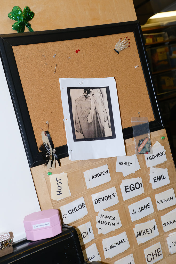 Image of vintage SNL Cast and Crew shirt, hanging above the names of current SNL cast members. 