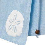 Light blue skirt detail image of a white sand dollar appliquéd detail and wooden bead detail.