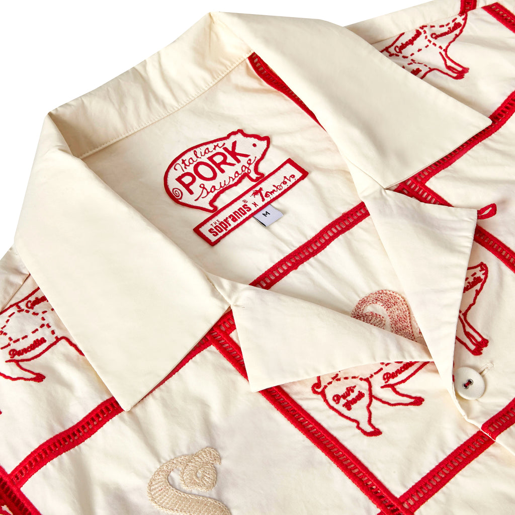 Close-up image of the custom woven 'The Sopranos' x Tombolo interior label, including special pig logo from Satriale's storefront, shot on a white background.